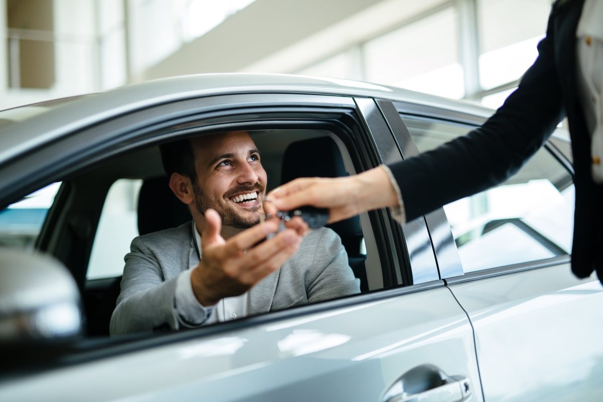Homme qui récupère ses clés de location de voiture